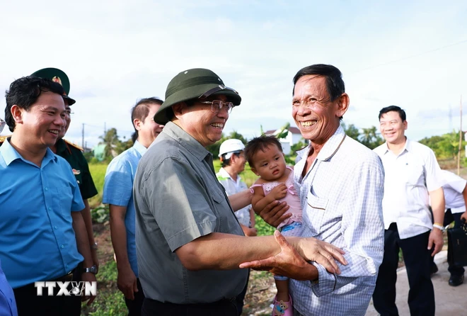 Thủ tướng Phạm Minh Chính thăm hỏi nhân dân khu vực Dự án Cao tốc Cần Thơ-Cà Mau. (Ảnh: Dương Giang/TTXVN)