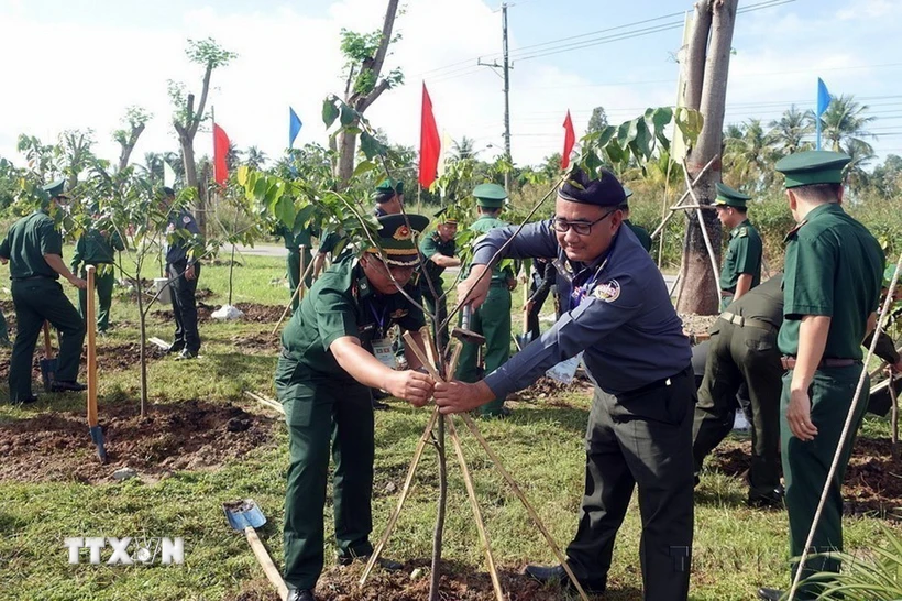 Đoàn đại biểu sỹ quan biên phòng Việt Nam - Campuchia trồng cây hữu nghị tại Đồn Biên phòng Lình Huỳnh, huyện Hòn Đất, tỉnh Kiên Giang. (Ảnh: Lê Sen/TTXVN)