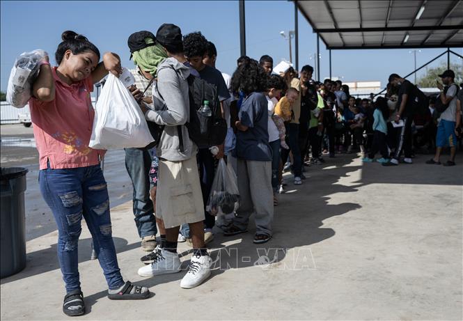 Người di cư chờ lên xe buýt để được trung chuyển khỏi bang Texas, Mỹ. Ảnh tư liệu: AFP/TTXVN