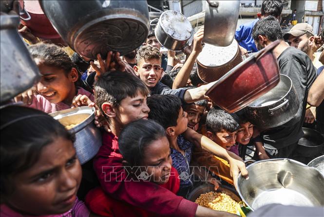 Người dân Palestine nhận thức ăn cứu trợ tại thành phố Gaza ngày 3-5-2025. Ảnh: THX/TTXVN