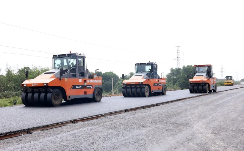 Đẩy nhanh tiến độ 5 dự án thành phần đường bộ cao tốc Bắc-Nam phía Đông Nhà thầu tổ chức thi công thảm nhựa những mét cuối cùng trên tuyến cao tốc Vạn Ninh-Cam Lộ đoạn qua tỉnh Quảng Bình. (Ảnh: Quốc Khánh/TTXVN)